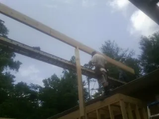 Carpenter setting a ridge beam over a new addition frame — Ice Dam Removal by Roofing Brothers in Morley